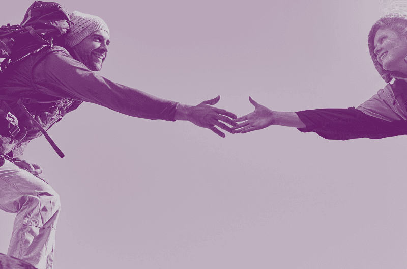 Image of hiker reaching out hand to help another hiker cross a rock gap to illustrate Why Trust Matters & How To Build Trust blog by Lodestar Marketing Group